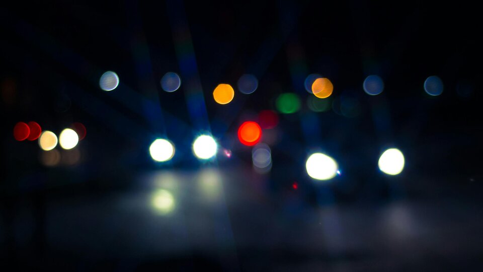 Bokeh photograph of street and auto headlights at night.