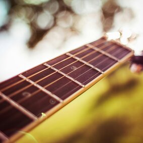Selective Focus Photography of Brown Guitar Bridge.