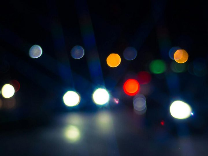 Photo of blurry headlights on a dark night.