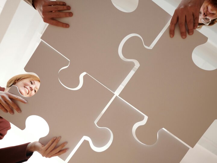 Individuals construct a life-size puzzle.